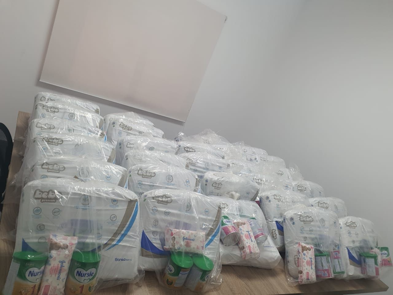 Une bénévole remet un sac de produits pour bébé à une mère.
