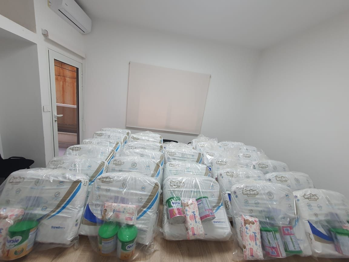 Des familles reçoivent du lait, des couches et des lingettes pour leurs bébés dans les locaux de Red In Circle, septembre 2021.