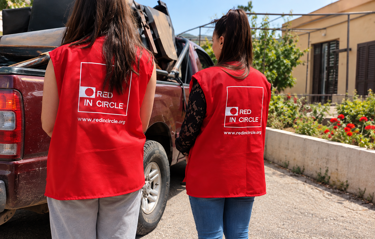 Des bénévoles de Red In Circle, vêtues de gilets rouges, préparent la distribution d’aide humanitaire et de fournitures aux familles dans le besoin.